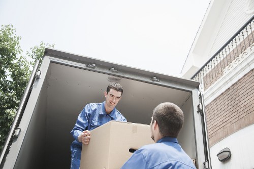 Professional movers carrying household items through a central London property entrance