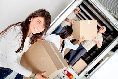 Professional mover handling boxes and furniture near Aldwych buildings